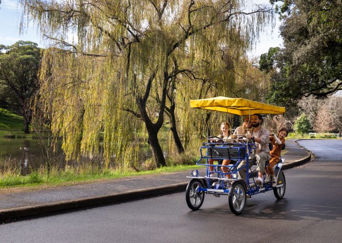 Family enjoying a day out in a hired 4-seat pedal car from Centennial Park Cycles, Centennial Park