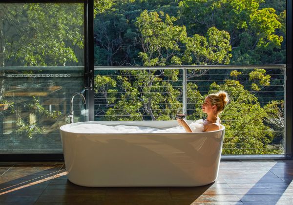 Woman relaxing in the bath with views at Spicers Sangoma Retreat, Bowen Mountain