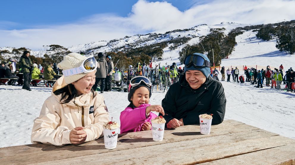 Family warming up with a hot chocolate at Thredbo ski resort in the Snowy Mountains