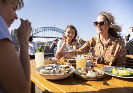 Friends enjoying food and drink at Opera Bar on Sydney Harbour
