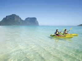 Couple enjoying a scenic kayak by Lagoon Beach on Lord Howe Island with Mount Gower as the backdrop Kayaking, Lord Howe Island