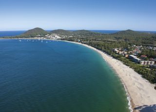 Coastal aerial of Shoal Bay beach in Port Stephens with views towards Mount Tomaree Shoal Bay, Port Stephens