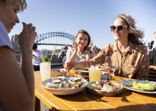 Friends enjoying food and drink at Opera Bar on Sydney Harbour
