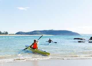 Couple enjoying a morning paddle at Palm Beach on Sydney's northern beaches.