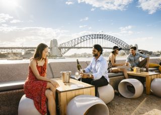 Couple enjoying champagne with harbour views at Opera Bar, Sydney