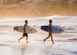 Surfers heading for a morning surf, Bondi Beach, Sydney