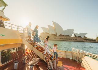 Family walking down stairs with Opera House in background, Sydney Harbour Ferry, Sydney
