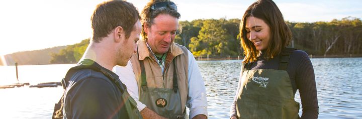 Couple enjoying a tour with Captain Sponge's Magical Oyster Tours on Pambula River, Pambula