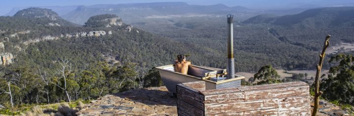 Woman enjoying Bubbletent Australia's outdoor bathtub with scenic views over the Capertee Valley