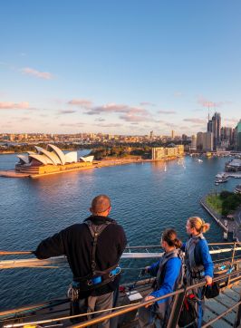 Friends enjoying a twilight BridgeClimb Sydney experience overlooking Sydney Harbour