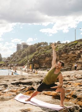 Group enjoying a yoga session by the ocean, Freshwater Beach