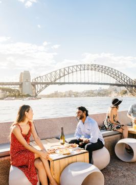 Couple enjoying food and drink with harbour views, Opera Bar, Sydney