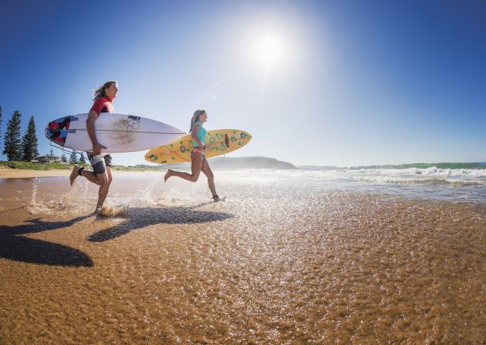 Two surfers heading out to enjoy the morning waves at Sydney's Palm Beach.