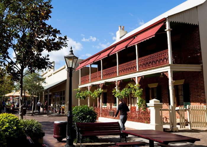 A woman walking by a two-storey heritage building, Windsor