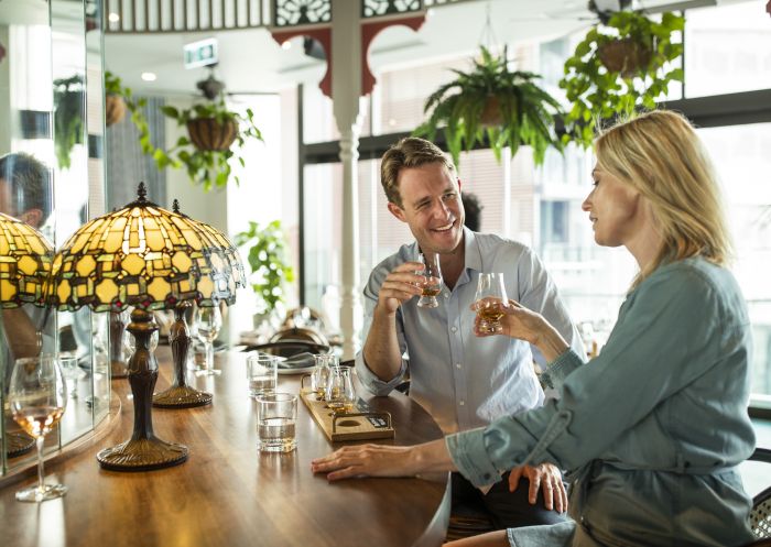 A couple enjoying a whiskey tasting at NOLA Smokehouse and Bar in Barangaroo