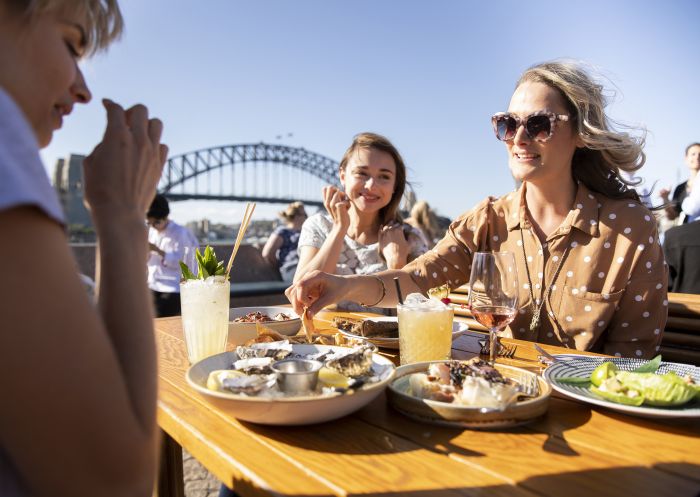 Friends enjoying food and drink at Opera Bar on Sydney Harbour