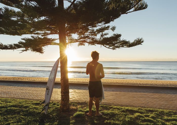Surfer enjoying the morning sun at Manly Beach in Sydney North