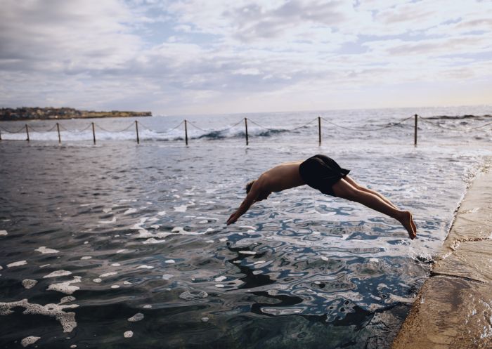 Man enjoying a morning swim at Wylies Baths in Coogee, Sydney East