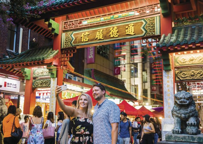 Couple take a selfie in front of the Chinatown gates on Dixon Street, Sydney City 