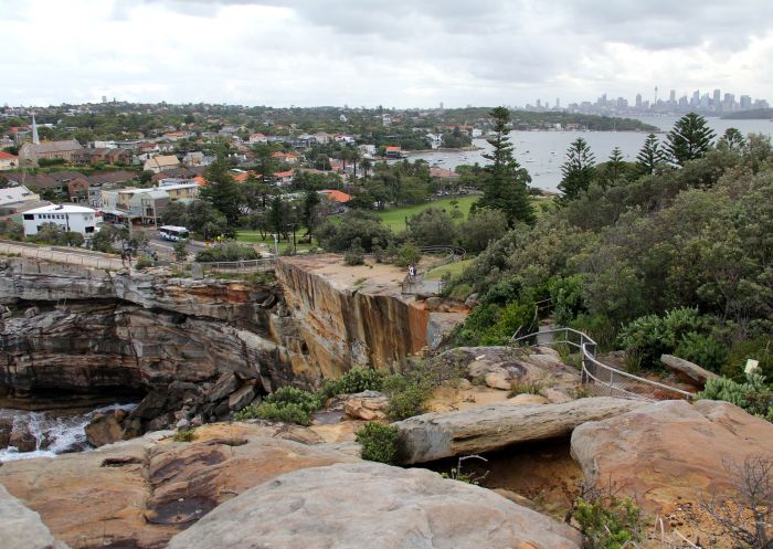 Gap Bluff Watsons Bay, coastal impacts, view towards Sydney business precinct, Sydney Harbour National Park. Caution, remain behind the fence