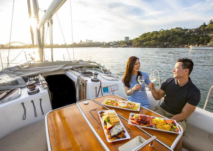 Couple enjoying food and drink on chartered sailing vessel on Sydney Harbour
