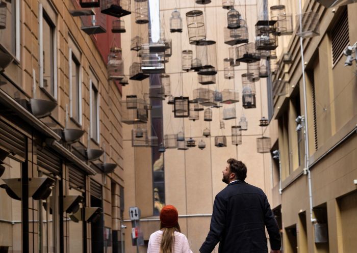 Father and daugher walking underneath the Forgotten Songs artwork in Angel Place, Sydney