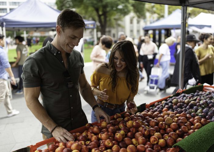 Couple browsing for fresh fruit at the Farmers Market in Centenary Square, Parramatta