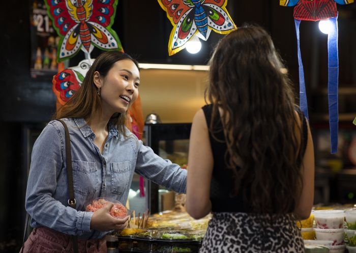 Friends buying Thai street food style desserts from Thanon Khaosan restaurant in Haymarket, Sydney City