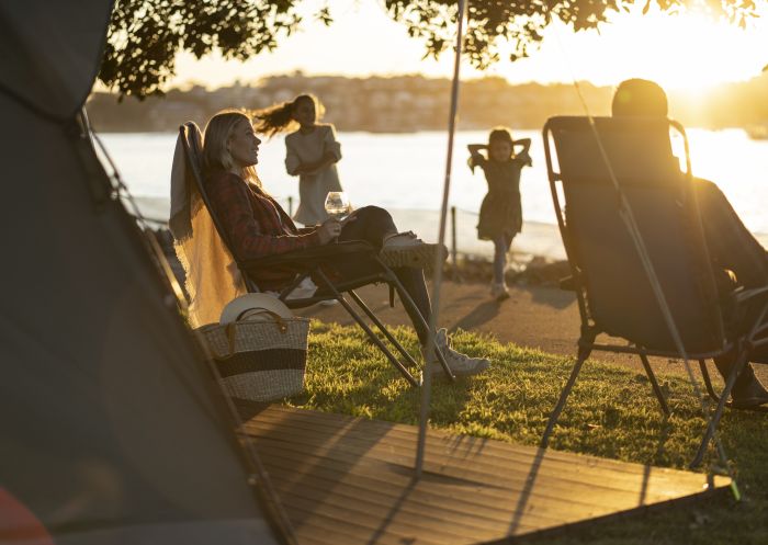 Family relaxing and enjoying their stay at Cockatoo Island's waterfront campground, Sydney Harbour