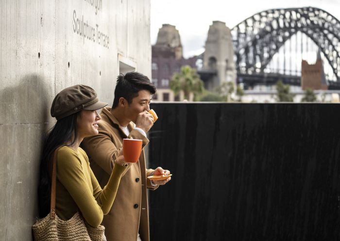 Couple enjoying coffee with views of Sydney Harbour from the MCA Cafe, The Rocks