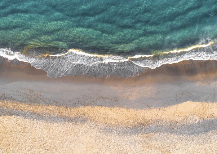 Aerial overlooking footprints along Garie Beach in Sydney's Royal National Park