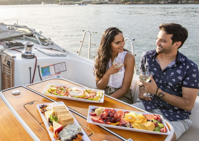 Couple enjoying food and drink on chartered sailing vessel on Sydney Harbour.