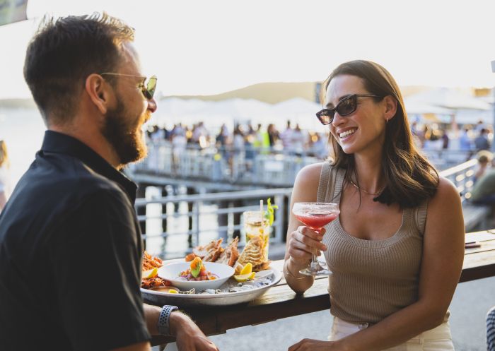 Couple enjoying food and drink at Manly Wharf Hotel, Manly