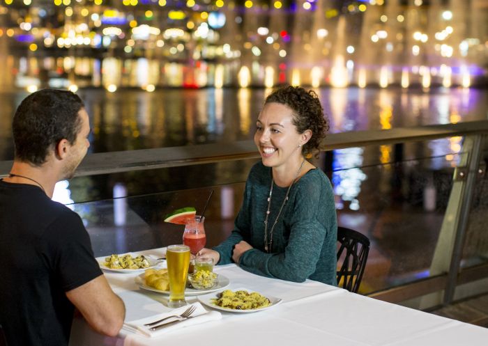 Couple enjoying the Aquatique Water Theatre while dining in Darling Harbour during Vivid Sydney 2014