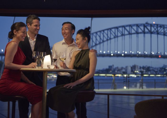 Couple enjoying an evening out with friends at Bennelong Restaurant, Sydney Opera House