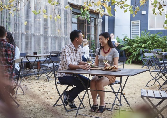 Couple enjoying food and drink at Three Blue Ducks Cafe in Rosebery, Inner Sydney