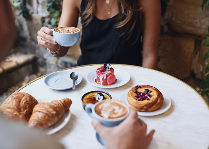 Woman enjoying coffee and pastries at La Renaissance Patisserie and Cafe, The Rocks