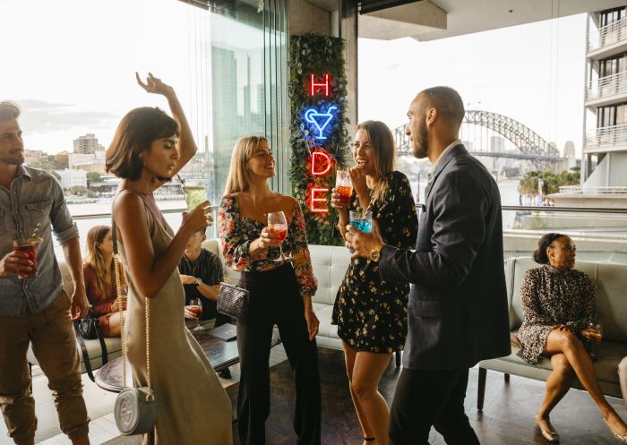 Friends enjoying cocktails with Sydney Harbour views at Hyde Hacienda Sydney Bar and Lounge, Sydney