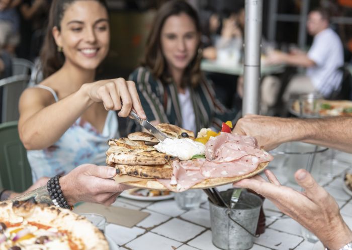 Couple enjoying food and drinks with friends at The Beresford, Surry Hills