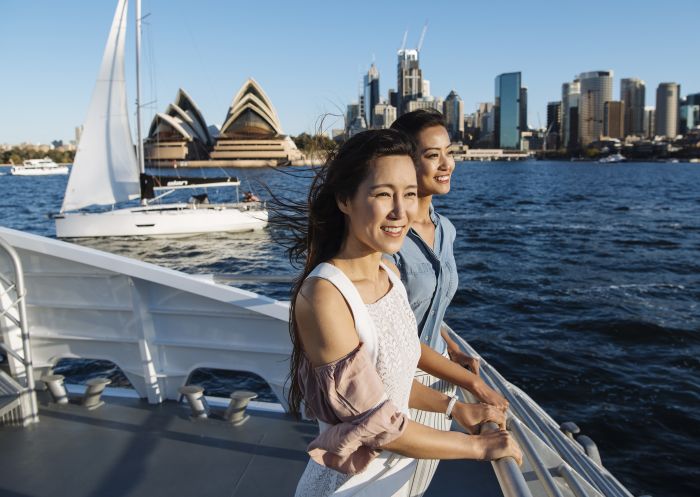 Friends enjoying coastal views onboard a Captain Cook Cruises whale watching tour off Sydney Heads