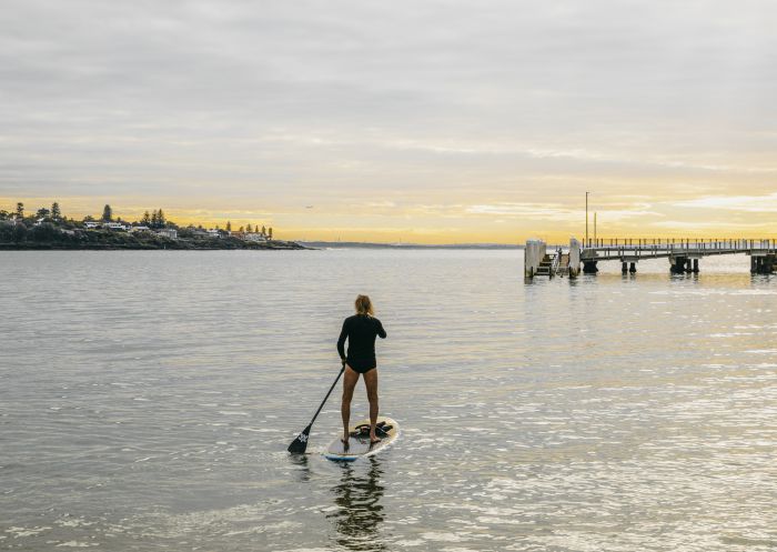 Man enjoying a morning of stand up paddleboarding in Port Hacking near Bundeena Wharf, Bundeena
