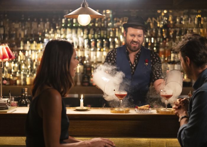 Couple watching a bartender preparing cocktails at The Cumberland in Manly