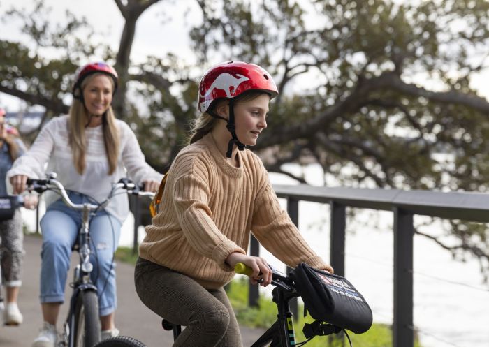 Family enjoying a ride through the Royal Botanic Garden Sydney on their hired bicycles from Bonza Bike Tours