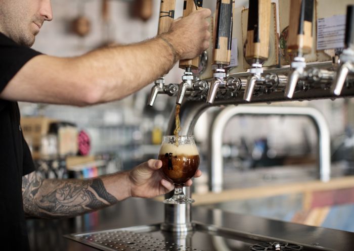 Bartender pouring a brown ale available from Small Batch by Batch Brewing Co., Petersham.