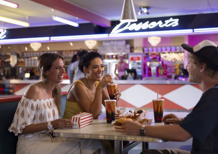 Friends enjoying pre-dinner food and drink at Retro decor at Skyline Drive In Blacktown