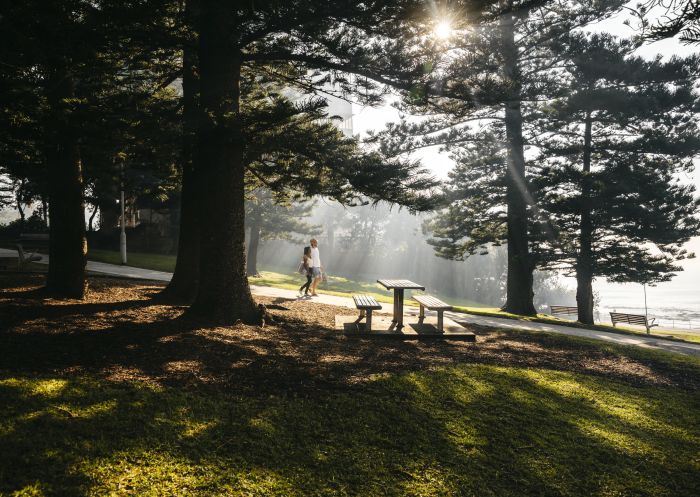 Couple walking through the sunlit Cronulla Park, Cronulla