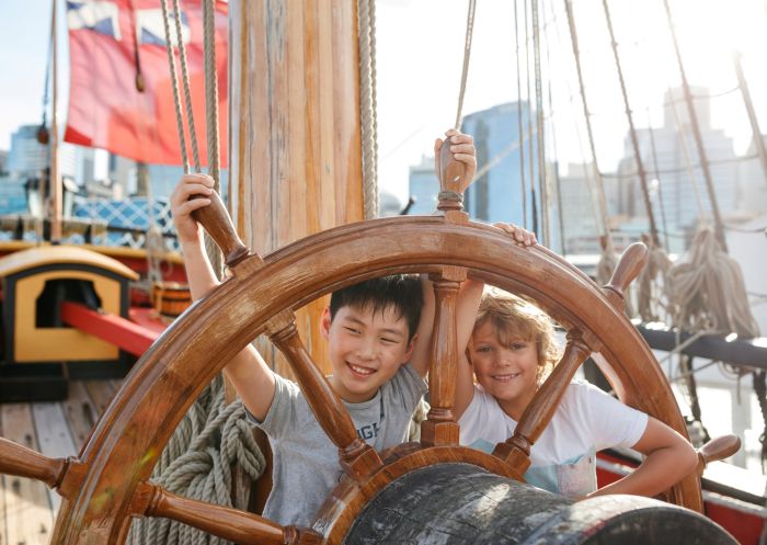 Kids at the wheel of the ship Endeavour in Australian National Maritime Museum, Darling Harbour