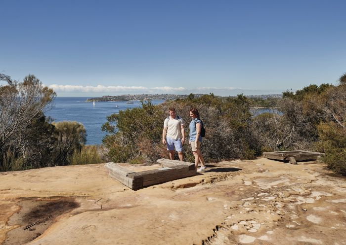 Couple visiting the Grotto Point Aboriginal engravings along the Spit Bridge to Manly walk