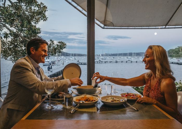 Couple enjoying food and drink with views across Balmoral Beach at Public Dining Room, Mosman