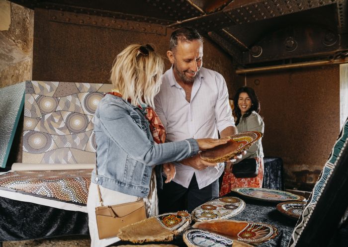 Couple browsing through Aboriginal artwork for sale at the Blak Markets on Bare Island, La Perouse